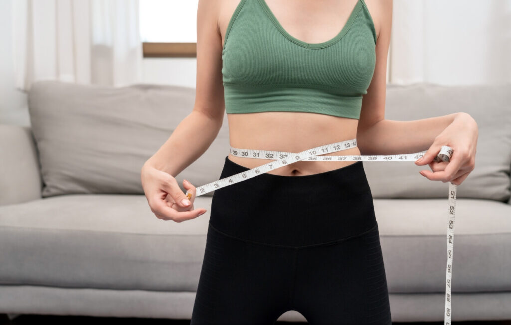 sporty-woman-in-sportswear-is-measuring-waist-circ-2024-10-18-07-24-22-utc (1)