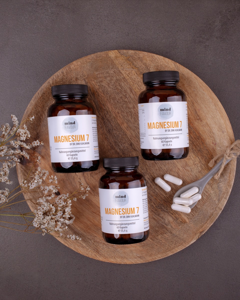 Three magnesium supplement bottles on a wooden tray.