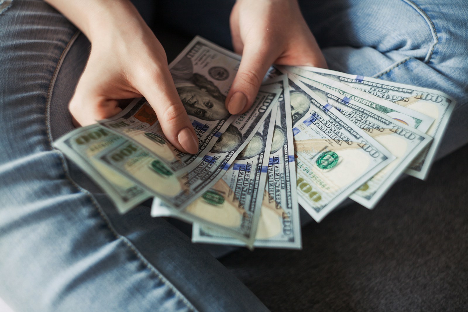 Hands holding dollar bills.