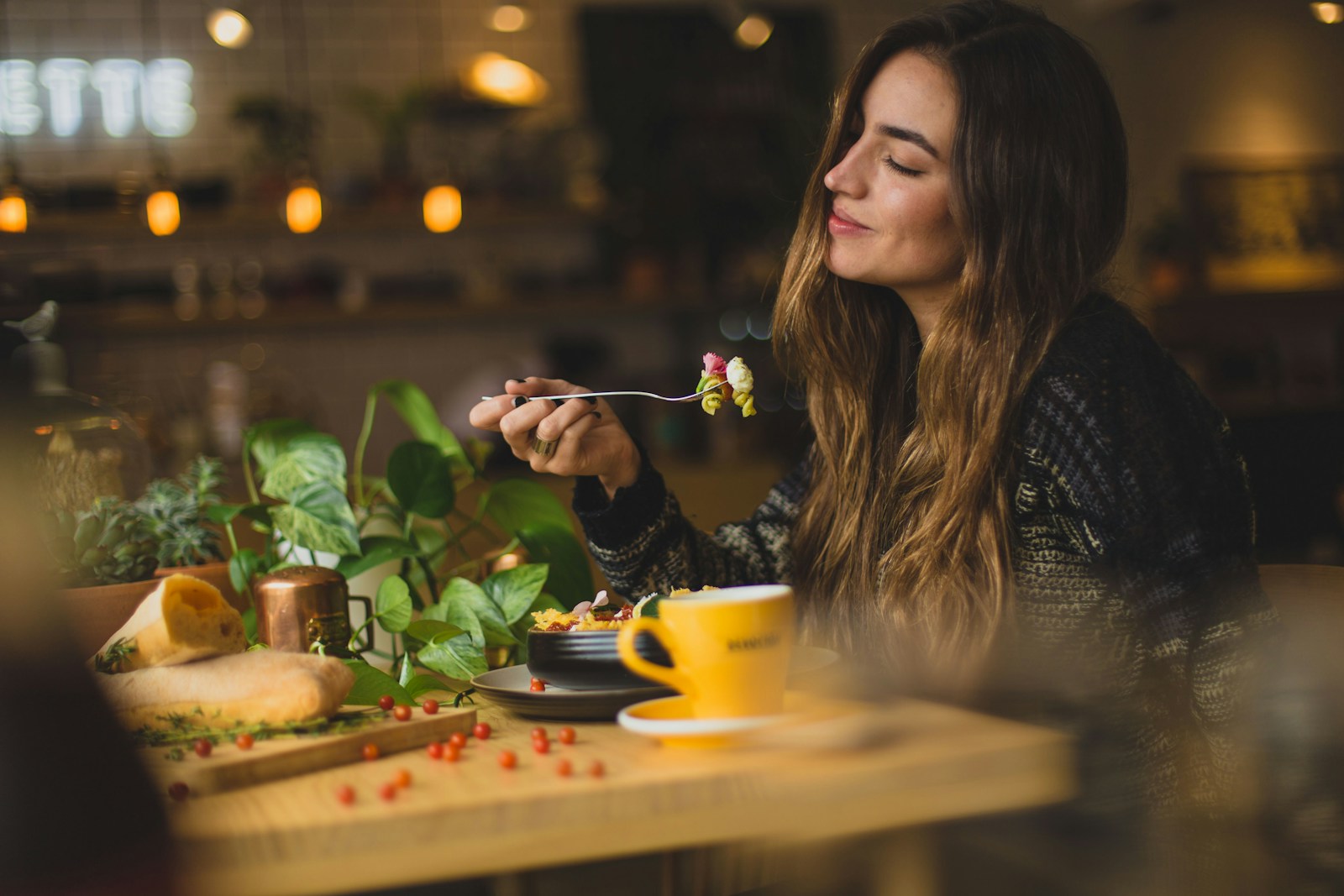 An adult eating a meal at a restaurant table.