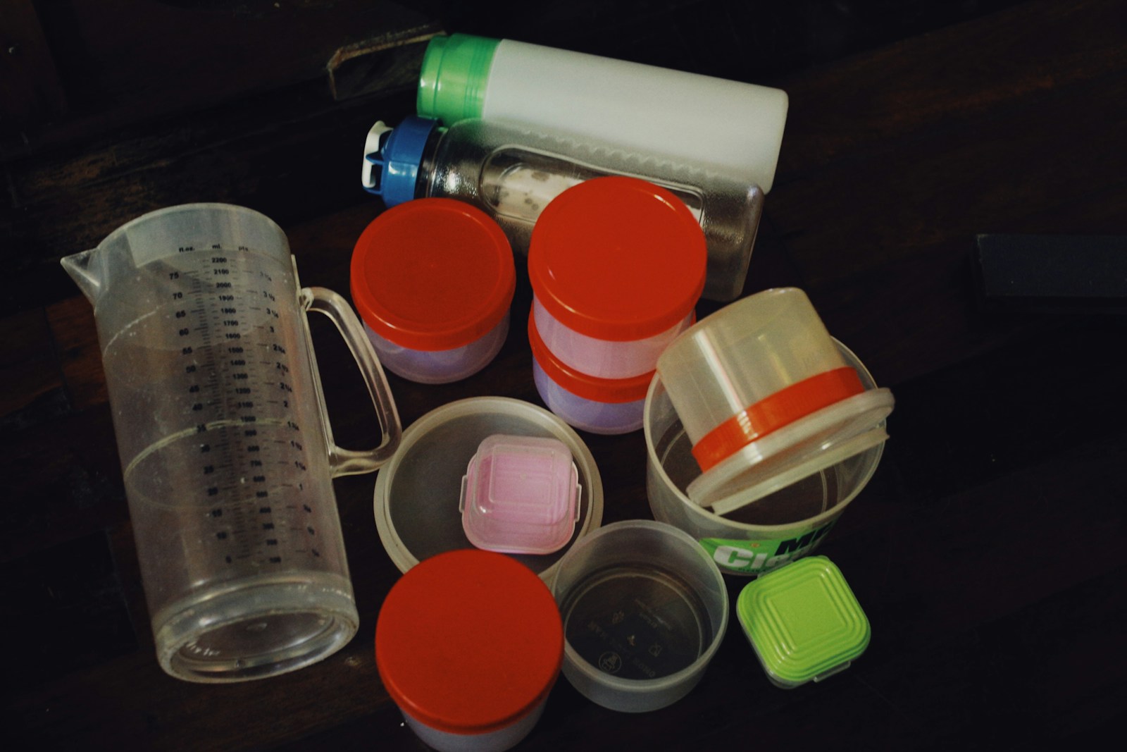 Assorted closed food containers and a measuring jug.