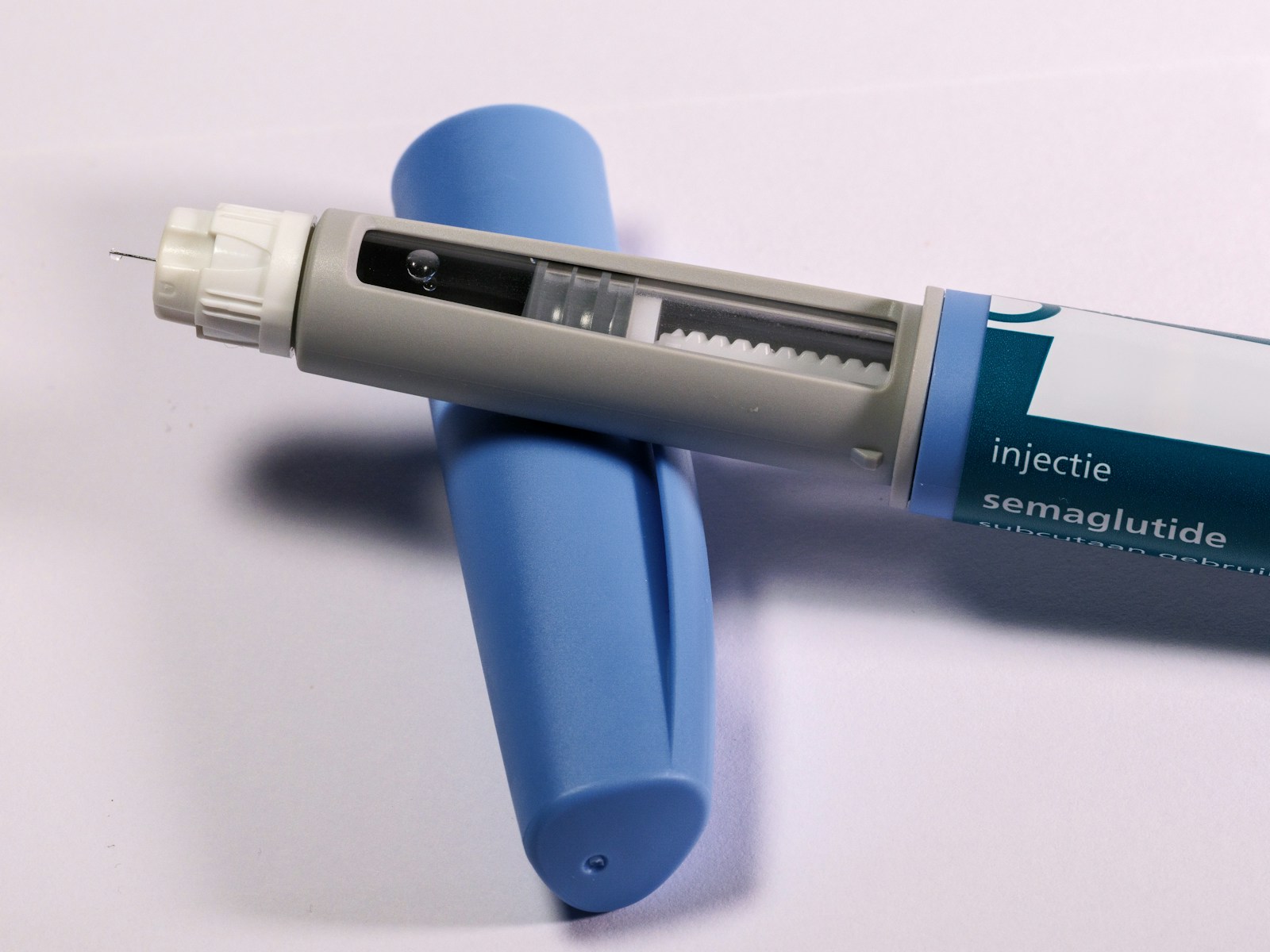 A semaglutide pen beside packaging with non-English text.