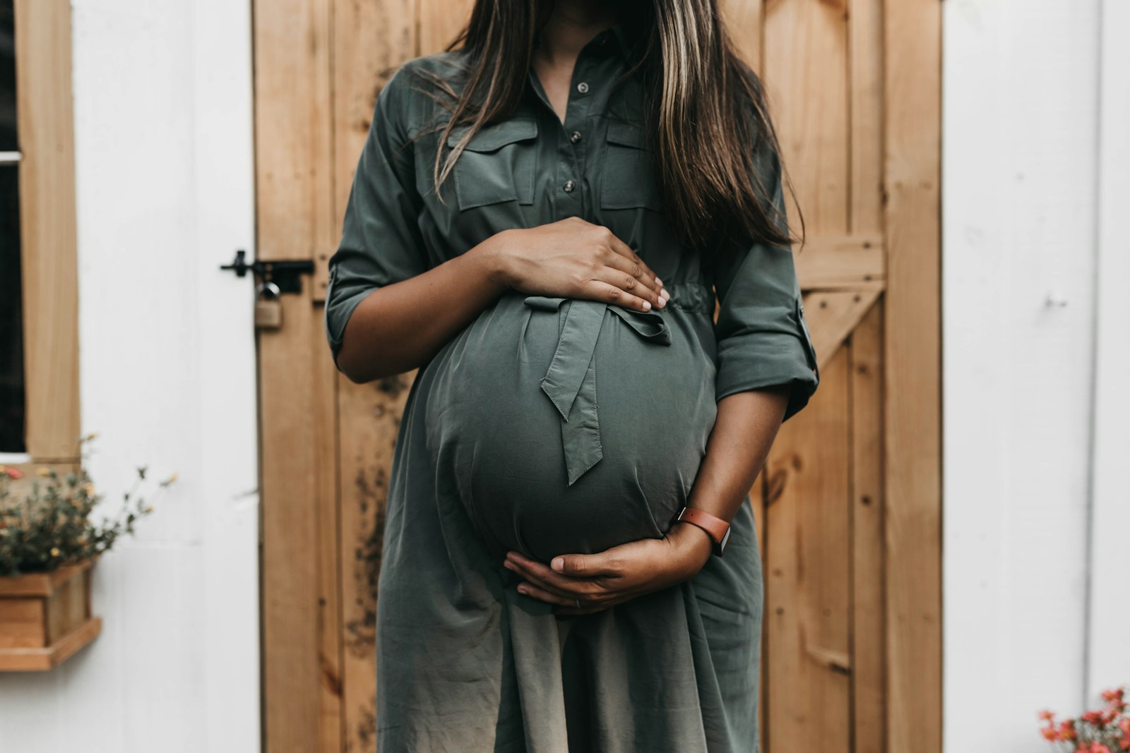 A pregnant adult resting hands over the abdomen.