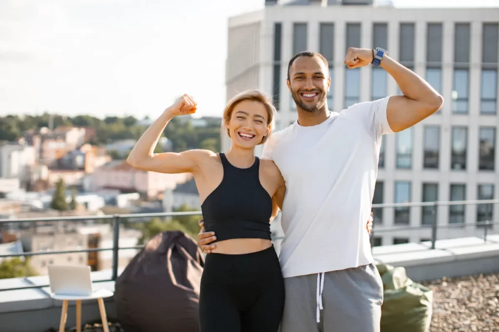 smiling-athletic-man-and-woman-showing-biceps