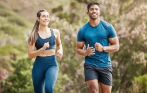 athletic woman and man running outdoors in daytime utc