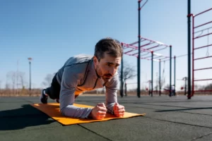 focused man performing plank exercise at outdoor g utc