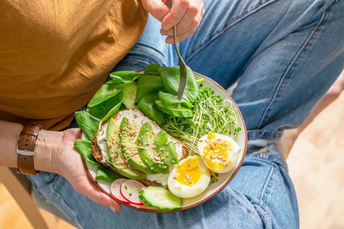 Meal bowl containing eggs, avocado, and vegetables