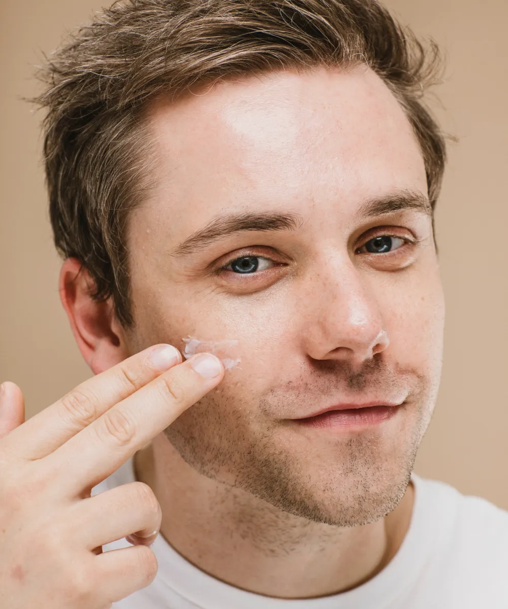 Man applying a skin-care product to his cheek