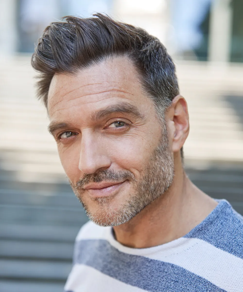 An adult man with gray hair wearing a striped shirt
