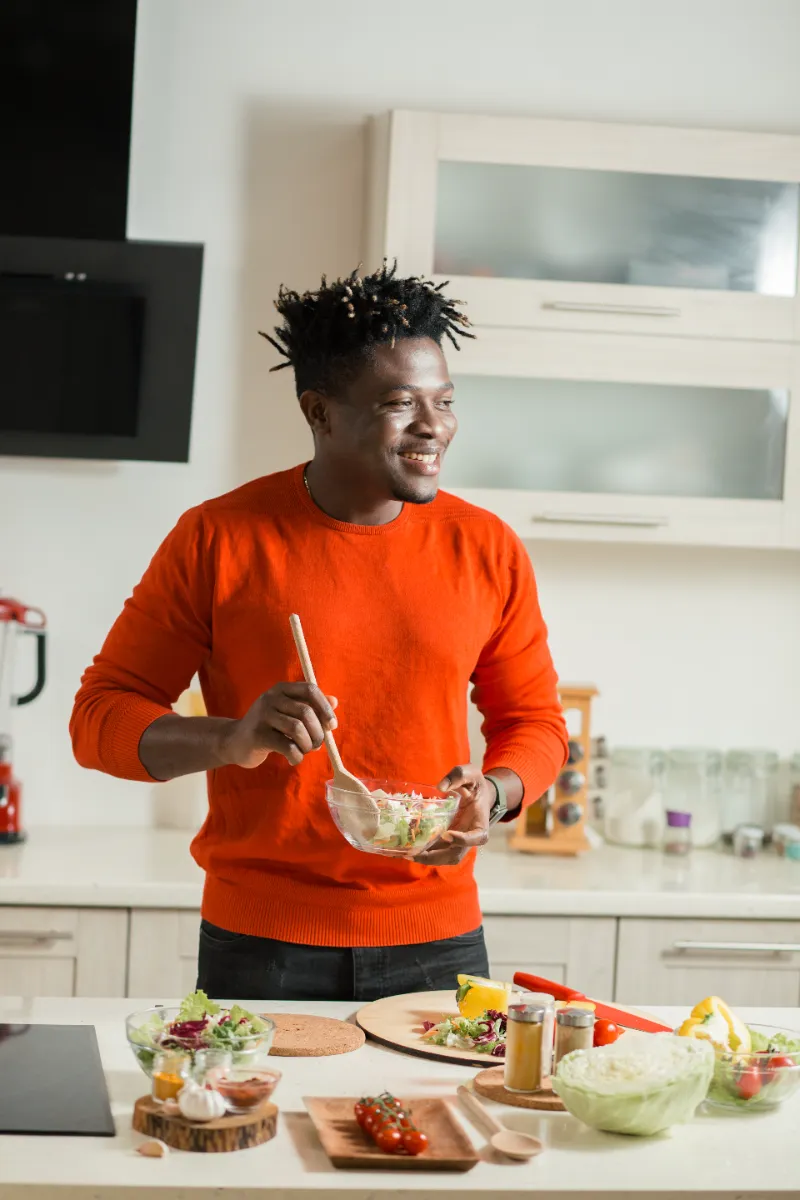 Man preparing a meal with vegetables at a kitchen counter