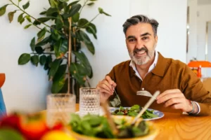 mature man enjoying a healthy green salad meal at utc