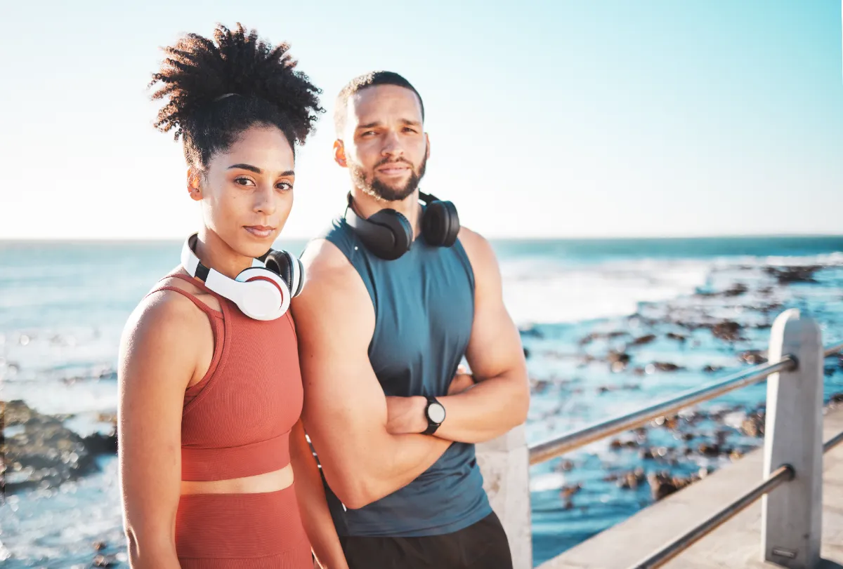 Two adults beside the water in exercise clothing