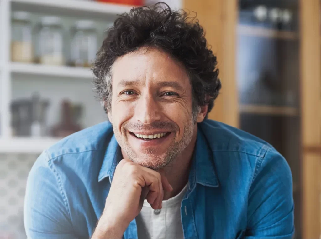 smiling-man-leans-on-kitchen-countertop-at-home-2026-01-09-10-22-20-utc