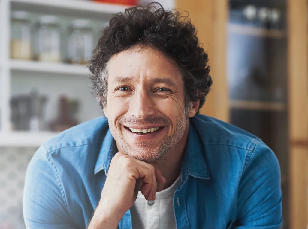 smiling-man-leans-on-kitchen-countertop-at-home-2026-01-09-10-22-20-utc