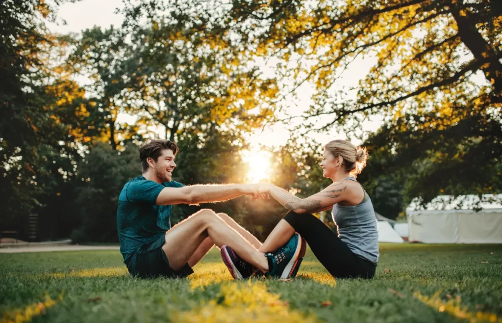 young couple exercising together at park utc