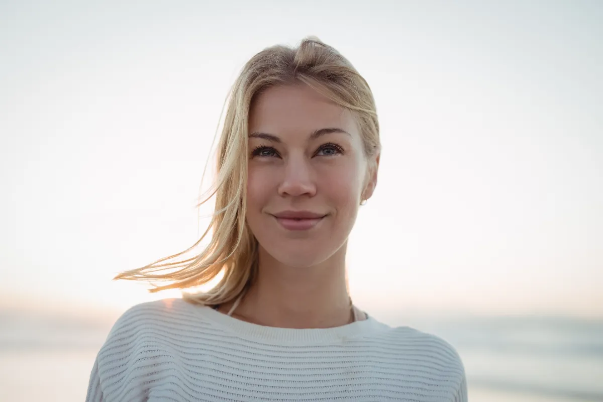 blond woman posing on beach at sunset utc