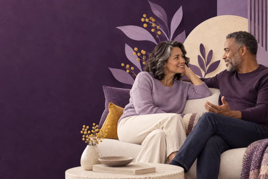 Two adults share a relaxed conversation on a sofa.