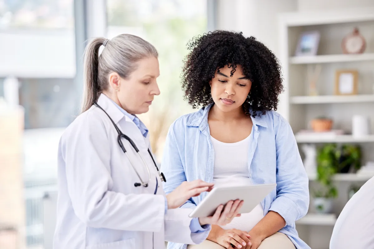 Two people reviewing a tablet in a clinical setting