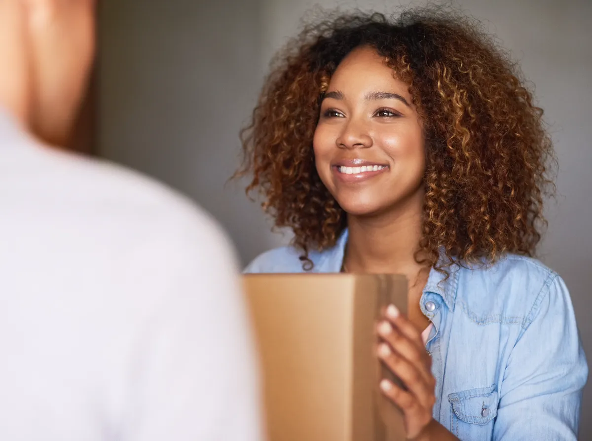 smiling woman receiving delivery in her home utc