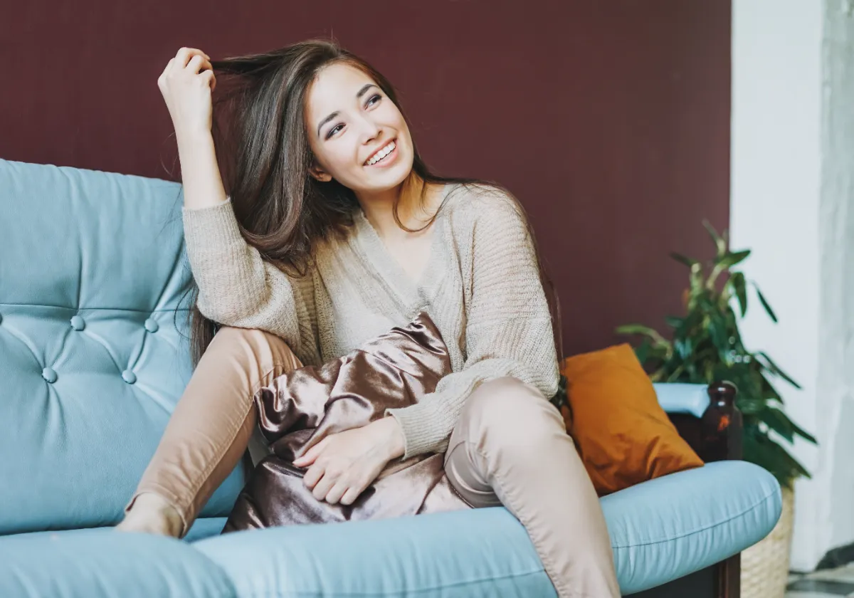 An adult relaxing on a blue sofa indoors.