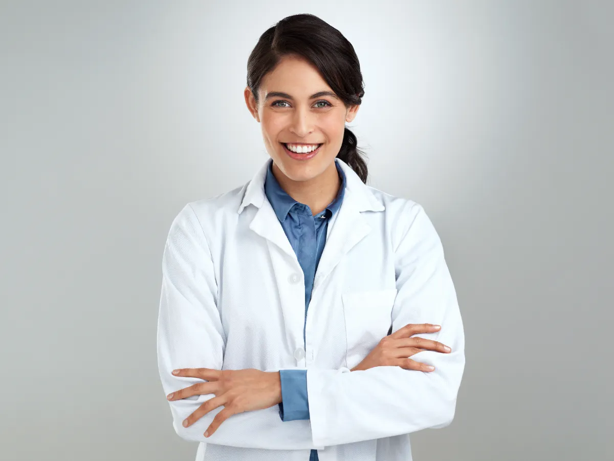 smiling woman with white coat and arms crossed utc