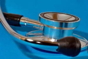Silver stethoscope resting on a blue surface