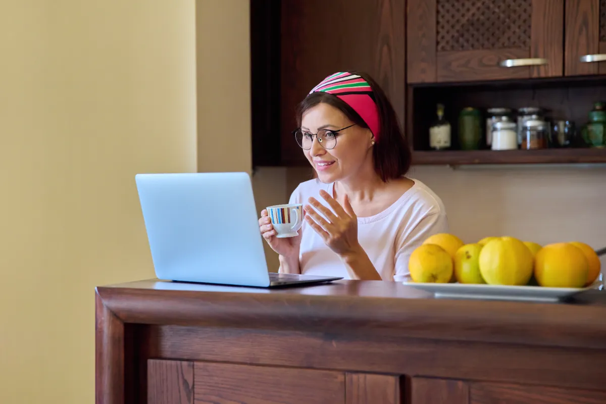 woman enjoying coffee and laptop in kitchen utc