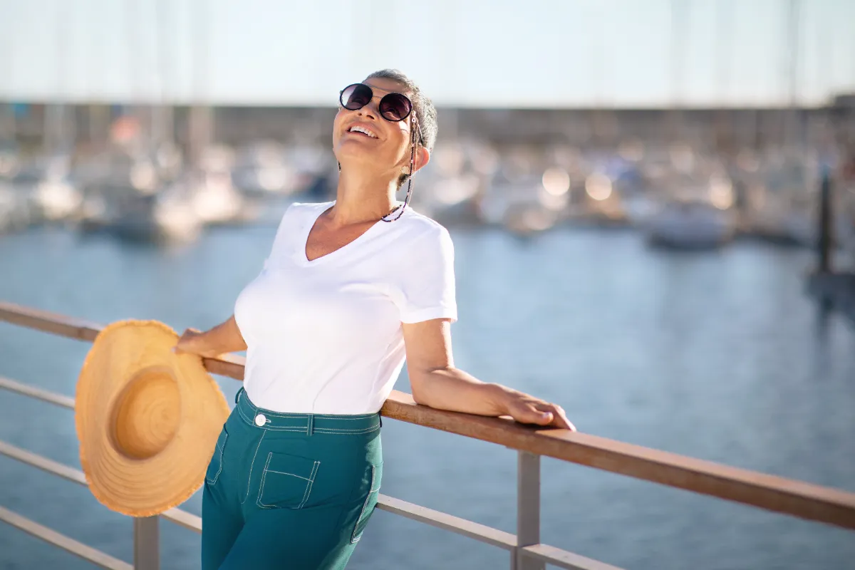 woman enjoys vacation by marina on sunny day utc