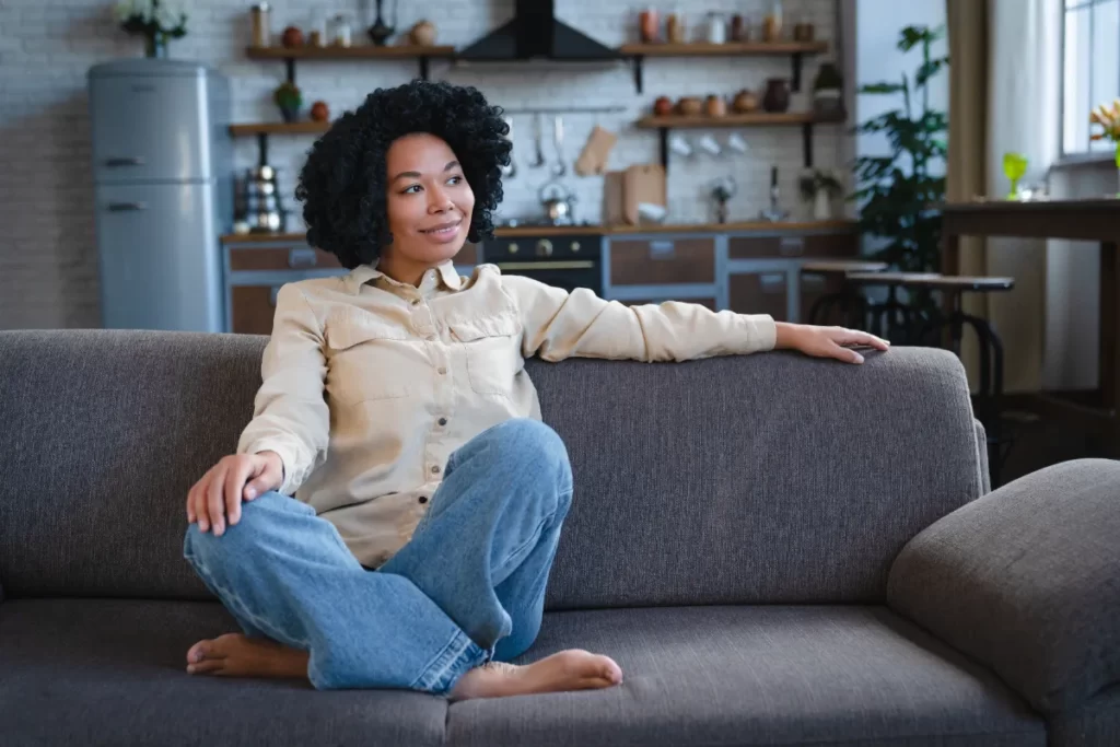 woman lounging comfortably on sofa at home utc