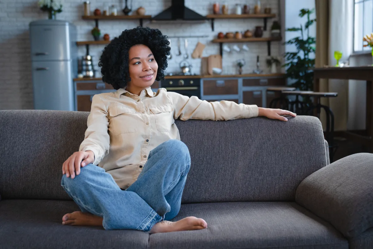 woman lounging comfortably on sofa at home utc