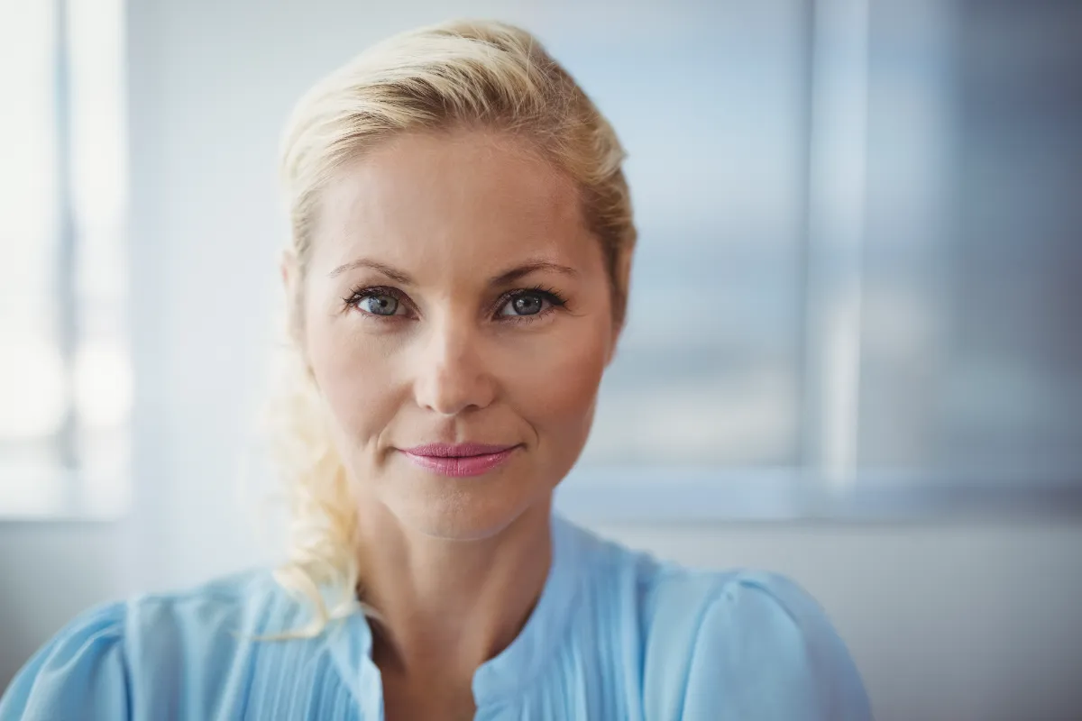woman with blond hair smiling in office setting utc
