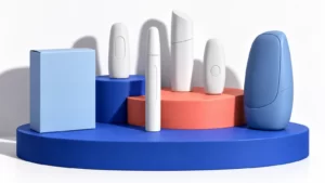 Abstract closed device sculptures and a blue carton on cobalt and coral steps.
